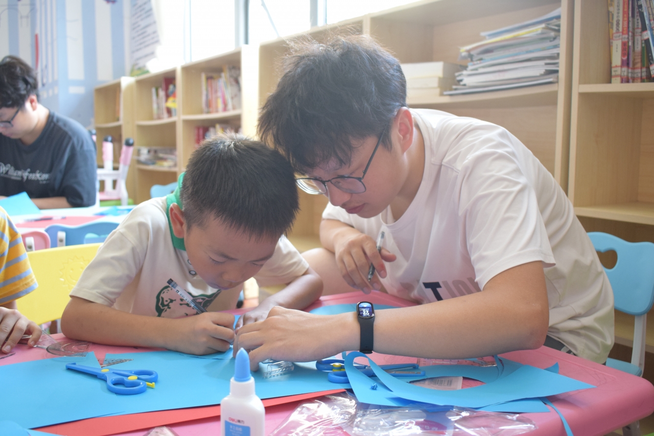 队员指导社区儿童制作红军帽2.JPG 队员指导社区儿童制作红军帽2.JPG