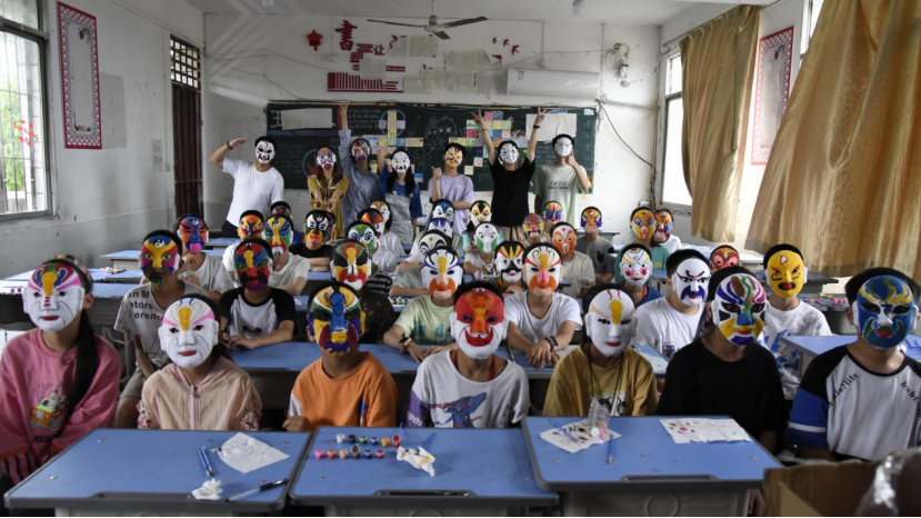 图为队员们与孩子们完成脸谱手工后的庆祝留影。中国青年网通讯员 周洪宇 摄.png