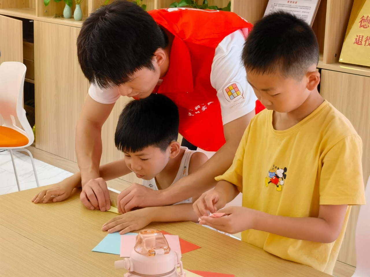 图为趣味折纸课上队员在手把手教孩子们。中国青年网通讯员 廖曼湫 摄.jpg